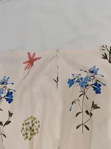 Détail d'une robe fleurie avec une fermeture éclair invisible au dos et couture soignée