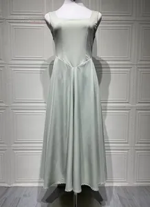Détail de la robe longue en satin vert clair avec encolure carrée et couture en V