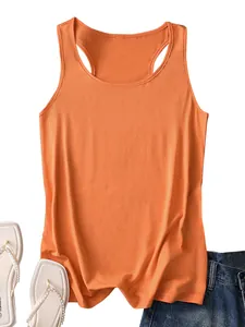 Flat lay of bright orange racerback tank top with white flip flops and denim jeans