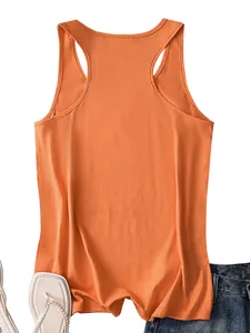 Flat lay of an orange racerback tank top paired with denim shorts and pearl sandals