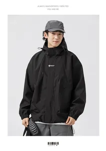 Close-up of black hooded jacket with white logo printing and large utility pockets