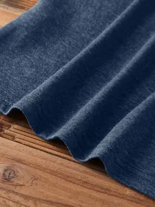 Detailed close-up of navy blue knit fabric with double-needle stitching on raw wood