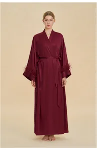 Detail of elegant burgundy satin robe with luxury detachable feather cuffs and waist tie