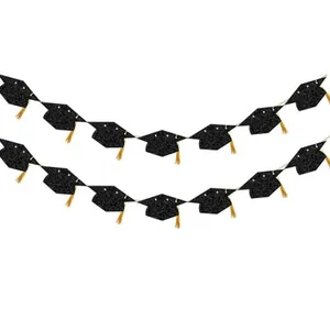 Macro shot of glittery black graduation cap banners with golden silk tassel details