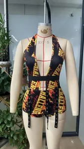 Détail du body dos nu avec décolleté en V profond, motif flamme et œillets en métal