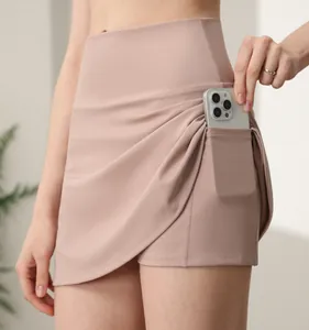 Detail of high-waisted pink sports skort side pocket holding a mobile phone