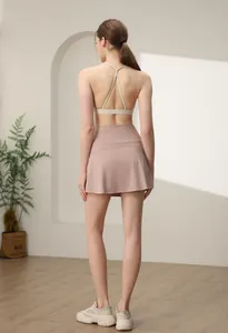 Detail of cross-back sports bra and high-waisted pink athletic skirt from the back view
