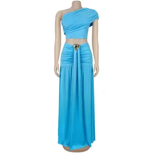 Détail d'un ensemble bleu deux pièces avec crop top froncé et jupe à boucle dorée
