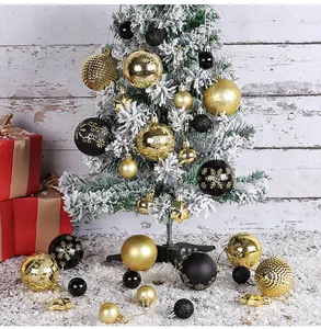Close-up of black and gold Christmas ball ornaments with snowflake patterns on a tree