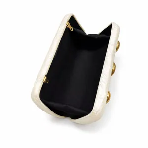Close-up of pearl acrylic clutch bag with marble texture and black interior lining