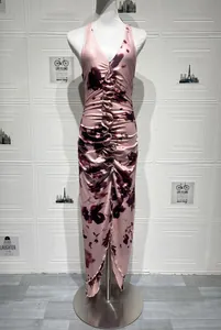 Detail of pink tie-dye halter dress featuring front ruffle trim and pleated texture