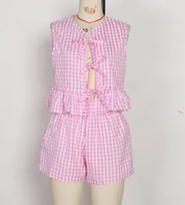 Détail d'un ensemble vichy rose avec nœuds et ourlet à volants sur mannequin de couture