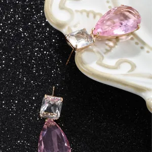 Elegant rose gold drop earrings featuring pink pear-shaped and clear square gemstones