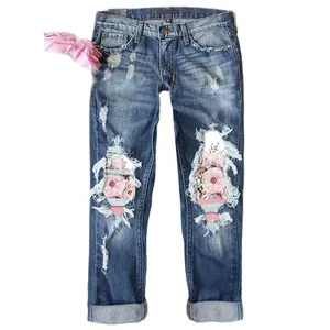 Loose straight-leg distressed blue jeans with floral lace patches and ripped details