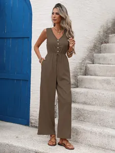 Detail of sleeveless deep V-neck jumpsuit featuring front buttons and drawstring waist