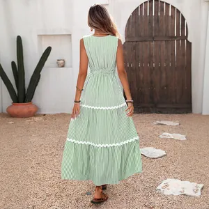 Rear view of tiered blue striped maxi dress featuring white wavy lace trim details