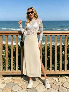 Détail d'un haut en dentelle blanche et d'une jupe midi en maille beige fendue