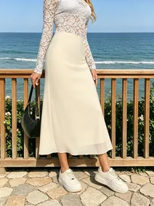 Détail d'une jupe mi-longue crème avec fente latérale idéale pour un look de vacances
