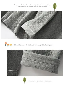 Detail of grey quilted cotton pajama set with white piping and round buttons
