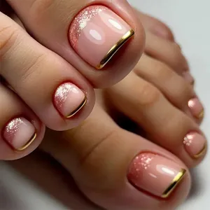 Macro shot of nude pink press-on toenails with rose gold glitter and metallic French tips