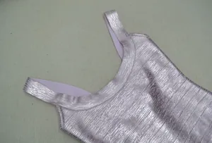Detailed close-up of light purple metallic textured fabric with wide U-neckline and straps