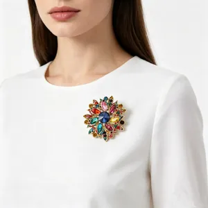 Gros plan détaillé d'une grande broche fleurie en cristal coloré sur un vêtement blanc