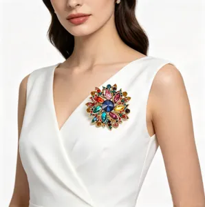 Détail de broche fleur en cristal multicolore sur robe élégante blanche col en V