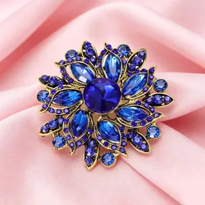 Gros plan détaillé d'une broche fleur vintage avec cristaux bleus sur satin rose