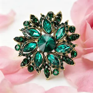 Macro d'une broche fleur en cristal vert nichée dans des pétales de fleurs roses
