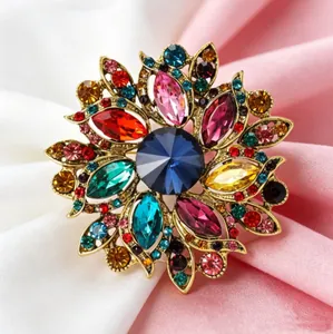 Vue macro d'une broche tournesol avec cristaux multicolores et gemme bleue centrale