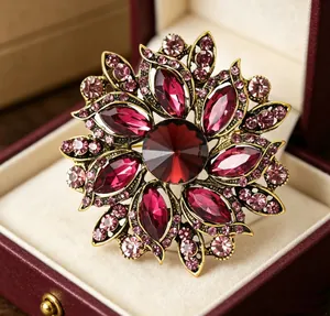 Gros plan d'une broche fleur rétro avec grande pierre rouge et cristaux violets