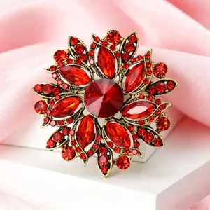 Gros plan sur la broche fleur vintage avec cristaux rouges et base en métal doré