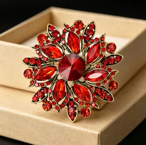 Gros plan d'une broche fleur vintage avec cristal rouge et base dorée au style antique