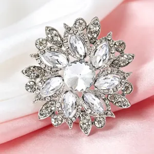 Détail d'une broche florale argentée avec des strass étincelants en plusieurs couches