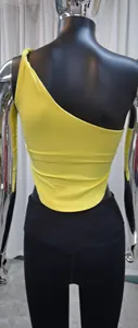 Dettaglio del top da yoga giallo monospalla con orlo asimmetrico e design a nodo