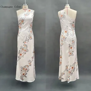 Détails de la robe longue en satin champagne à fleurs avec coupe à une épaule nue