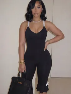 Detail of black V-neck jumpsuit with white straps and elegant ruffled hem design