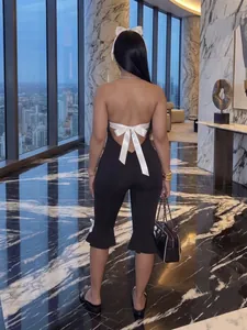 Elegant backless black jumpsuit with white satin bows and halter neck style