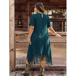 Detail of teal waffle texture dress with asymmetrical tassel hem and back keyhole