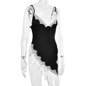 Detail of black satin slip dress with white eyelash lace trim and asymmetric hem