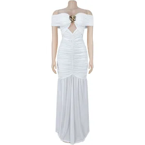 Détail de robe blanche à épaules dénudées avec ornement de cœur doré et tissu froncé