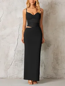 Détail d'une robe longue moulante noire avec découpe à la taille et empiècement mesh