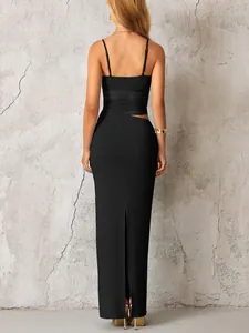 Détail d'une robe longue noire moulante avec empiècements en résille et fente haute