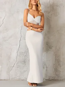 Détail de robe longue blanche moulante avec empiècements en résille et fente latérale