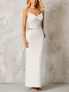 Détail d'une robe longue blanche avec découpe à la taille et texture en mesh plissé
