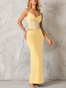 Robe moulante jaune avec empiècements en résille transparente et détails découpés