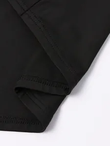 Détail de l'ourlet à double couture et texture en maille fine d'une robe noire moulante