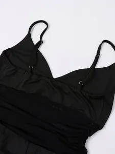 Détail du col en V plongeant et empiècement en résille sur une robe noire moulante