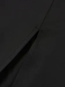 Détail de la couture de la fente et du tissu haute densité d'une robe noire moulante