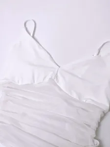 Détail de la robe en maille froncée blanche avec fines bretelles et décolleté en V